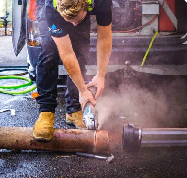 Cutting a drain pipe section with a grinder